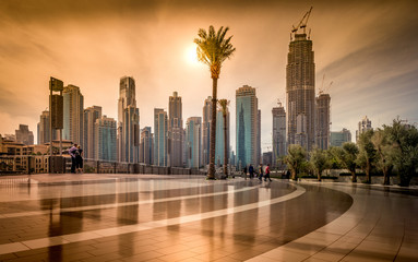View of the skyline of Dubai center in the evening, skyscraper in the background and reflection on the ground, memories of a day in United Arabian Emirates, amazing city in middle-east Asian holidays