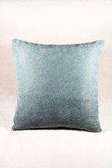 Vibrant teal pillow on a white velvet background
