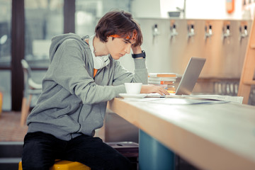 Concentrated student working on his thesis in the cafe