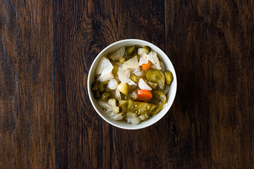 Mix of Turkish Pickles with Hot Green Pepper, Cabbage, Sauerkraut, Carrot and Cucumber in Bowl.