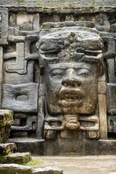 The Olmec style mask on the side of the Mayan temple of Lamanai in Belize