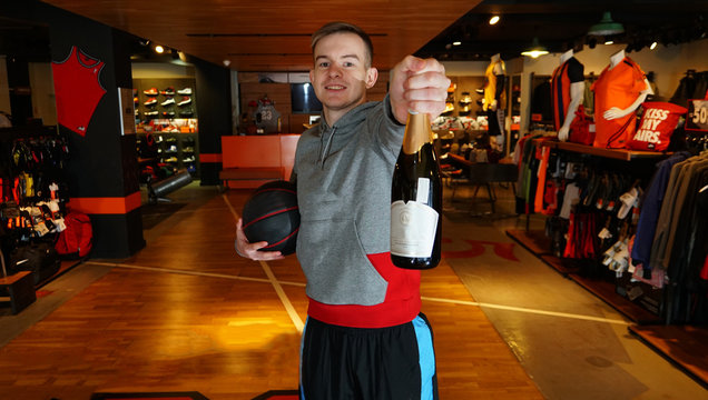 Young Man In Sportswear With Wine Bottle And Ball At A Basketball Store