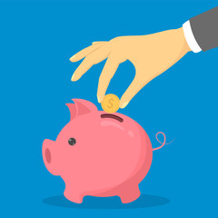 Hand put golden coin in pink piggy bank