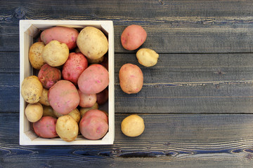 Obraz na płótnie Canvas Fresh raw potatoes in a wooden box