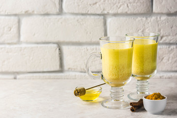 Golden milk with honey and cinnamon. Selective focus, space for text.