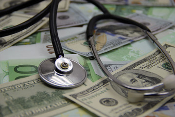 Pharmacy background on a wooden table. Medicine and health. Stethoscope and money on wooden background. Copy space for text. Expensive treatment