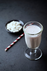 Glass of protein shake and glutamine. Nutrition for bodybuilding. Black stone background. Copy space.