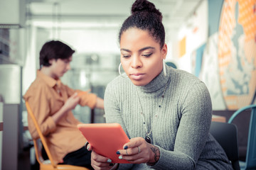 Young woman gripped with texting and not noticing her friend