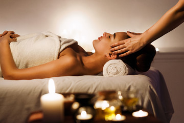 Fototapeta na wymiar Young girl having face massage, relaxing in spa salon