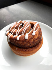 Homemade Fresh Cinnamon Roll / Bun with Cream Sauce served at Cafe Shop with Plate Portion