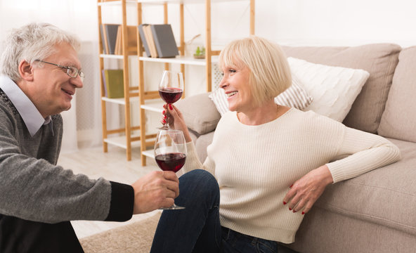 Senior couple enjoying glass of wine at home