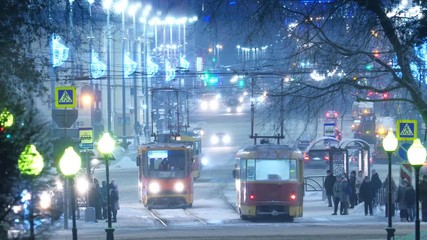 Traffic during winter on Lenin Ave in city of Yekaterinburg, Russia. Zoom in on tram stop. 4K UHD Timelapse.