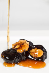 Healthy Food- Dried Plums Filled With Walnuts And Honey Flowing Down On Plums