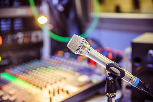 Microphone in the recording studio, equipment in the blurry background