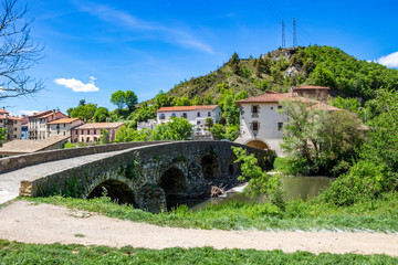 View to Villava with the medieval bridge over Ulzama River, at Villava, Navarre, Spain on a sunny May day