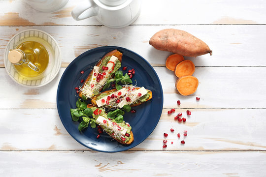 Warzywna potrawa obiadowa. Pieczone bataty z zielonym pesto, tofu i kiełkami.