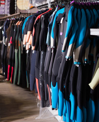 Image of colorful wetsuit hanging in the  store for surfing