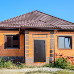 The house with plastic windows and a roof of corrugated sheet. R