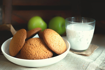 Daily healthy breakfast. Homemade oatmeal cookies, milk, fruit on dark  background.