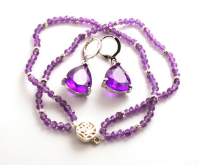Necklace and two purple earrings on a white background
