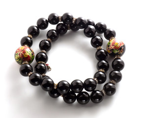 Two bracelets with black beads on a white background