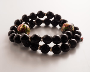 Black bead bracelets on white background