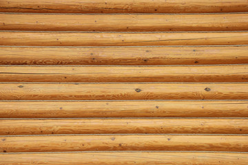 Wooden wall made of logs. Wooden background or texture.