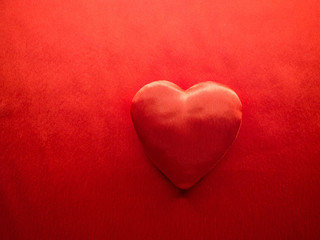 Simple classic red silk handmade heart on red background