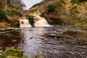 Fototapeta na wymiar Crammel Linn Waterfall Pool, as the River Irthing flows over the 10 metre falls it marks the boundary between Northumberland and Cumbria just north of Gilsland, England