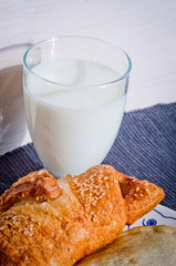 butter croissant with sesame seeds baked with fresh glass of milk