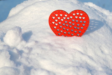 Valentines Day red heart in winter in the snow. Red wooden heart,  scene with love message.