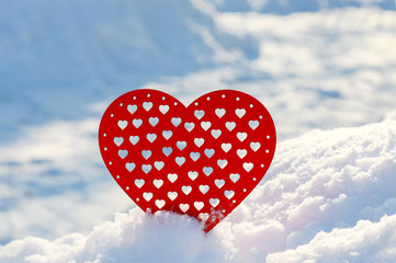 Valentines Day red heart in winter in the snow. Red wooden heart, winter scene with love message.