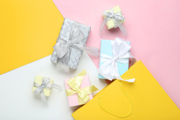 Shopping bag with gift boxes on colorful background