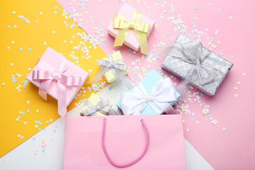 Shopping bag with gift boxes on colorful background