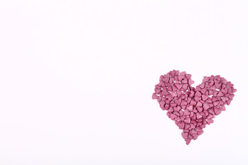Purple heart shaped sprinkles on white background