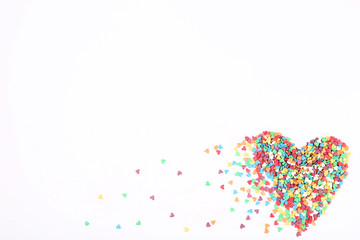 Colorful heart shaped sprinkles on white background
