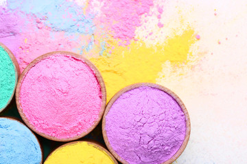 Colorful holi powder in bowls on white background