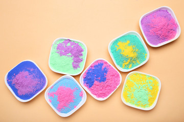Obraz na płótnie Canvas Colorful holi powder in bowls on beige background