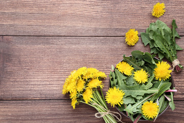 Yellow dandelions on brown wooden table