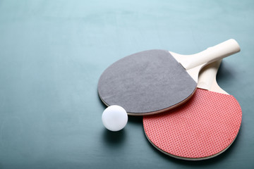 Table tennis rackets with ball on green background