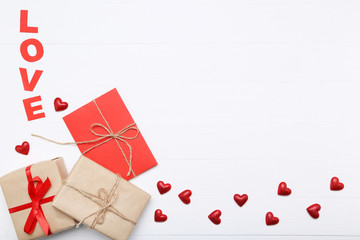 Red hearts with word Love and gift box on white background