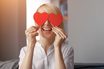 Cheerful woman with hearts near eyes