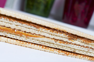 Cooking waffle cake. On the table lies a waffle cake, smeared with boiled condensed milk.