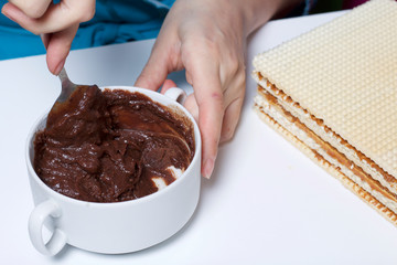 Cooking waffle cake. A woman mixes a mixture of cocoa and butter. Nearby are wafer cake layers smeared with boiled condensed milk.