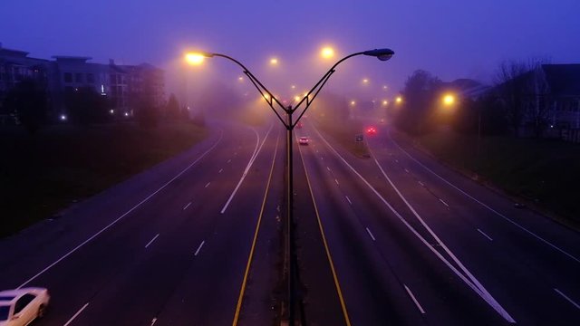 Slow motion footage of road car traffic at foggy night modern city