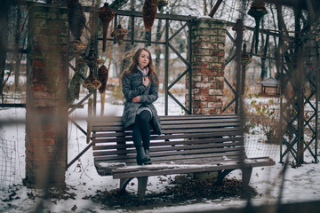 Fototapeta na wymiar A young woman walks in a winter park.
