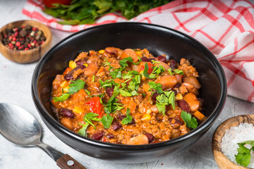 Chili con carne from meat and vegetables on stone table close up.