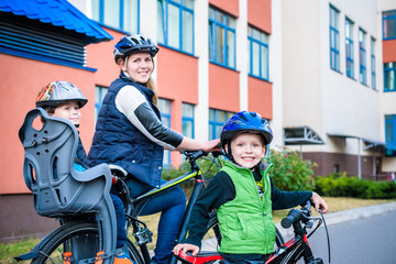 Obraz premium Family cycling, mother with happy kid riding bike outdoors