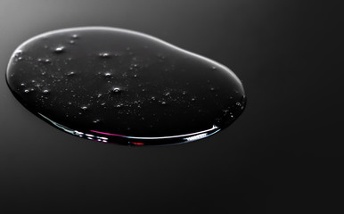 Gel serum solution liquid close up macro shot on black background.