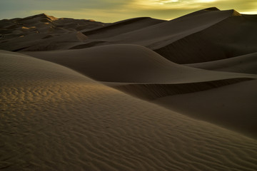 Fototapeta na wymiar sunrise walk in sand dunes, Imperial Sand Dunes, California, USA